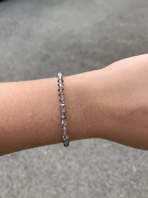 A person wearing a Crystal Satin Crystal Bracelet with diamonds on it.