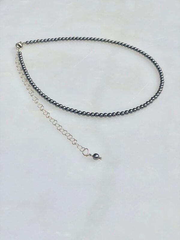 A 13-18” Grey Pearl Necklace/Choker with a silver chain and a silver bead.