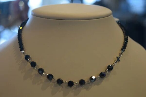 A 13-18" Hematite & Silver Rosary Necklace with black and silver beads on a mannequin.