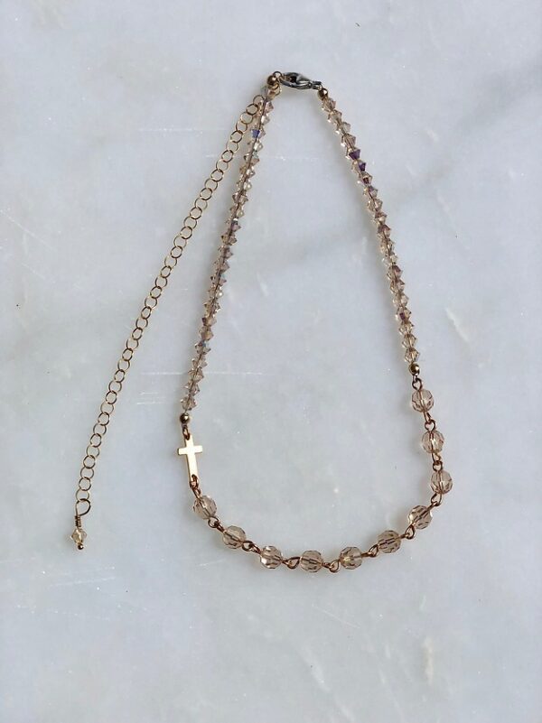 A 13-18" Light Silk Crystal with Gold Rosary Necklace with a gold chain.