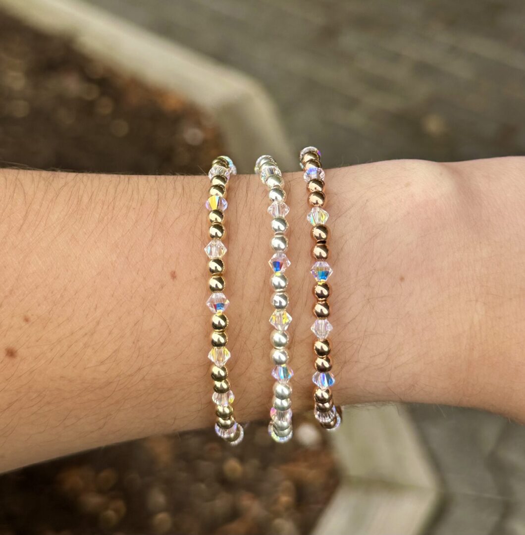 A person wearing the April Birthstone - Clear Crystal Stretch Bracelet adorned with Swarovski crystals on their wrist.