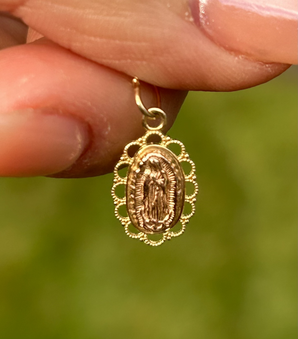 A person holding a 14K Two Tone Rose Gold and Yellow Gold Guadalupe Pendant.