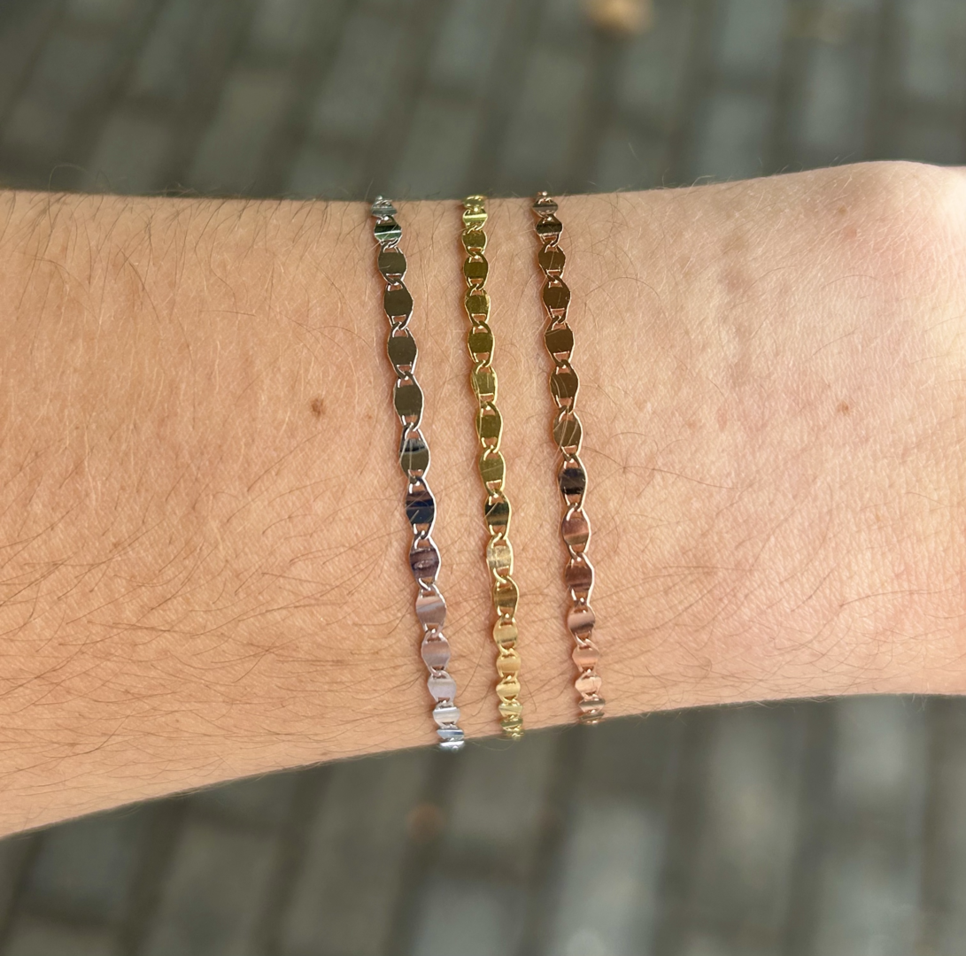 Two 7.5" 14K Gold Valentino Bracelets on a person's wrist.