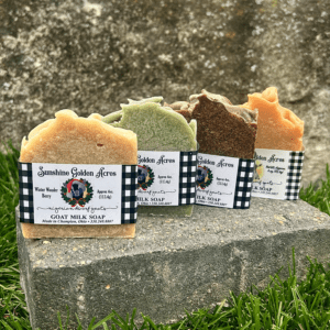 Four Sunshine Golden Acres Bar Soaps sitting on top of a block of grass.