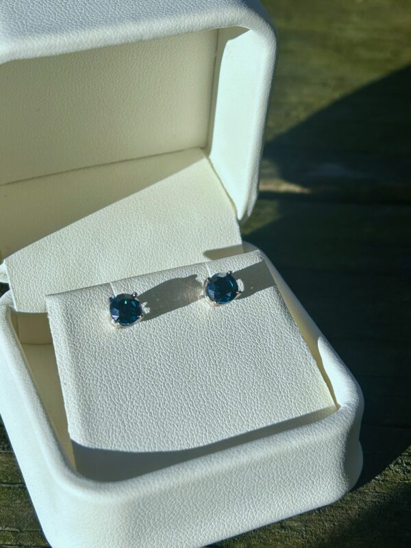 White Gold Blue Diamond stud earrings in a white box.